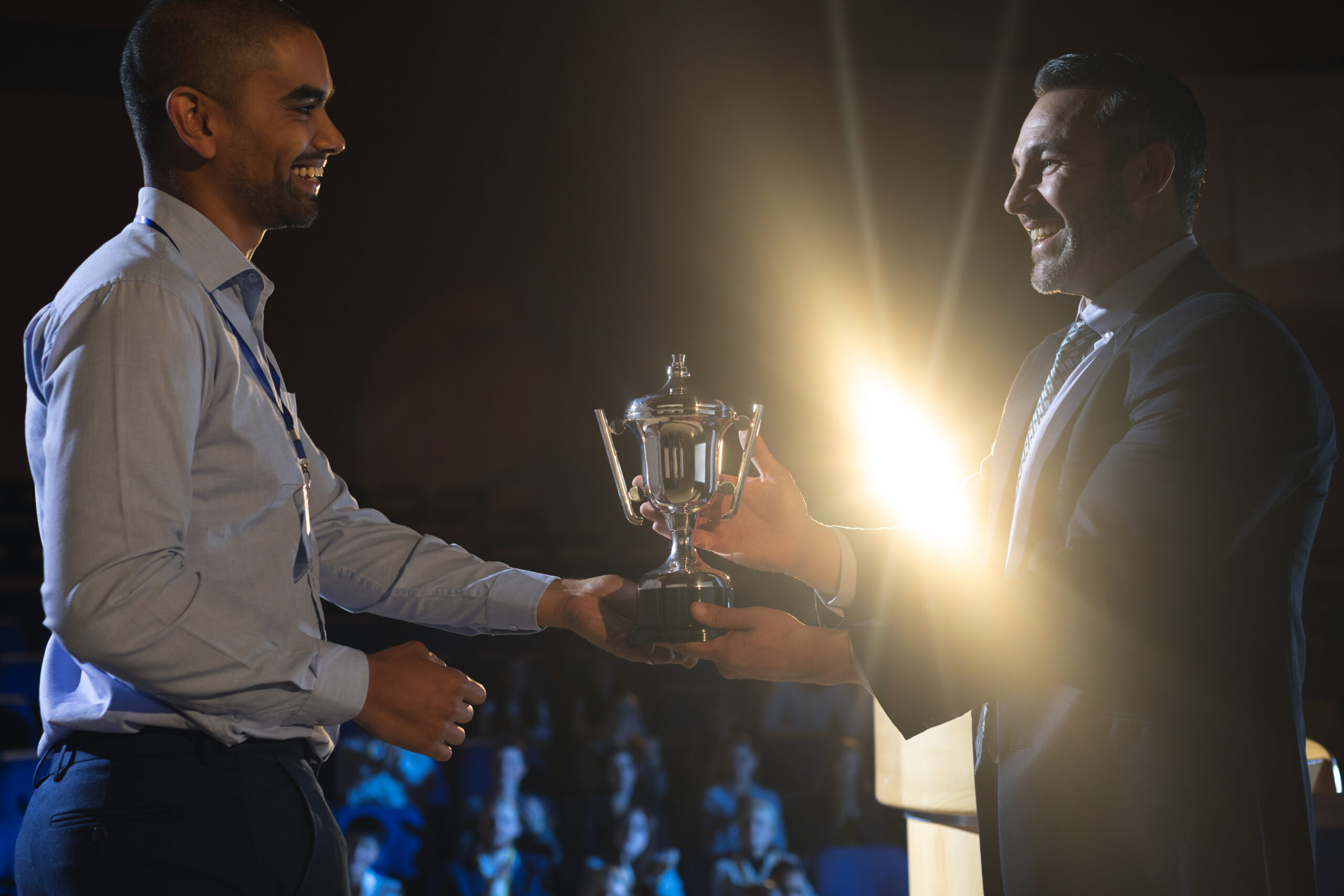 businessman-giving-trophy-business-male-executive-stage-auditorium-scaled.jpg